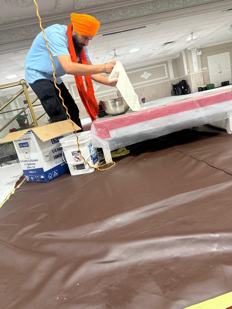 Volunteer preparing the hall for sewa