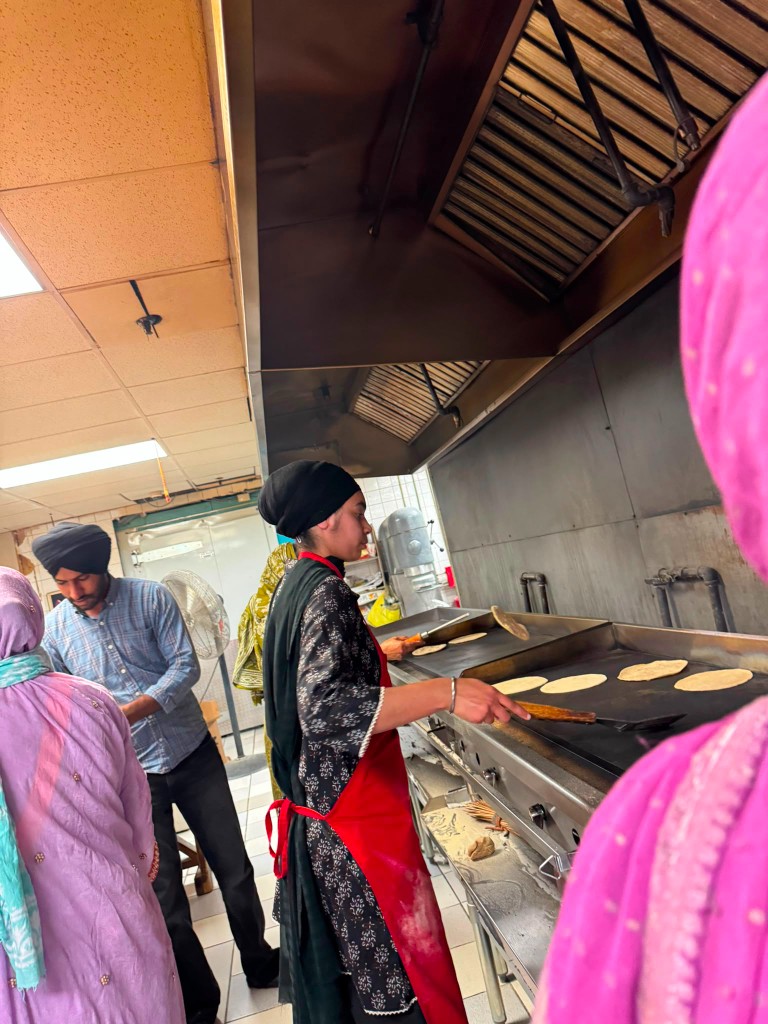 Volunteer cooking rotis on the langar griddle